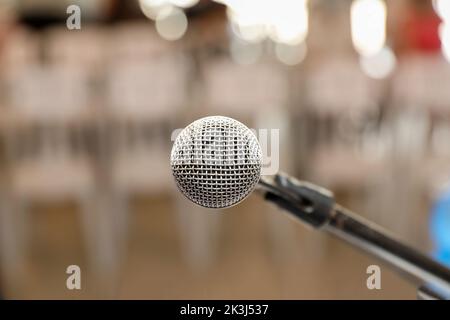 Microphone sur scène contre un arrière-plan de chaises. Banque D'Images