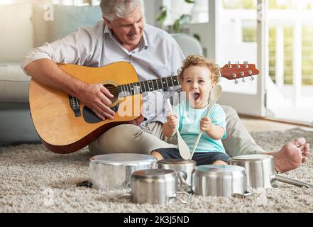 Musique, pots et batteur pour bébé avec vieil homme sur le sol du salon avec une poêle et des instruments de cuillère en bois avec sa guitare. Mémoire, sourire et senior Banque D'Images