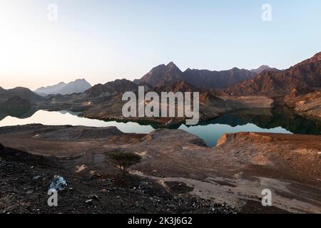 Magnifique lac Hatta vert profond avec montagnes rocheuses Hajar en arrière-plan. Vue d'ensemble du barrage Hatta aux Émirats arabes Unis. Banque D'Images