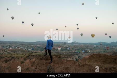 Jeunes hommes regardant des ballons d'air chaud au lever du soleil à Cappadoce Turquie, Kapadokya Goreme. Jeunes hommes caucasiens regardant le lever du soleil dans la vallée de la Cappadoce Turquie Banque D'Images