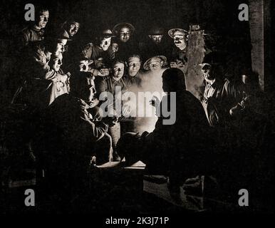 Les soldats se rassemblent dans un dugout pour une histoire ou un briefing militaire dans un dugout lors de la troisième bataille d'Ypres de 1917 – conçue par Sir Douglas Haig pour capturer la crête de Passchendaele. Photographie de Frank Hurley (1885 1962) un photographe australien. Banque D'Images