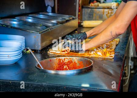 Cuisine turque de rue. L'homme se fait un gâteau traditionnel dans la vieille ville d'Antalya, Turquie Banque D'Images