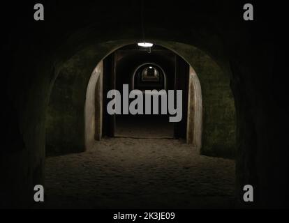 Un long tunnel sombre d'un abri de bombe avec une lumière à l'extrémité du tunnel. Abri d'un abri à la bombe en temps de guerre. Salle souterraine Banque D'Images