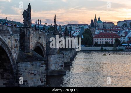Prague - République Tchèque - 08 01 2020 touristes en vêtements d'été se promenant sur le pont Charles pendant une nuit d'été avec un ciel coloré Banque D'Images