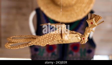 un oiseau en paille suspendu sur un fil. Fait à la main, traditionnel. Gros plan Banque D'Images