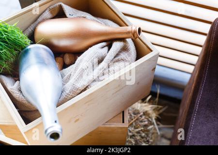 Deux bouteilles de vin vides dans une boîte en bois. Boîte à vin remplie de bouchons de bouteille et de tissu à sacochon Banque D'Images