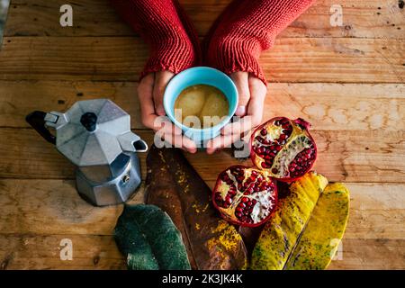 L'heure du petit déjeuner d'automne concept style de vie avec vue au-dessus de la personne tenant une tasse de café italien traditionnel moka chaud sur une table en bois avec l'automne d Banque D'Images