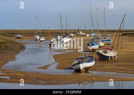 Vue sur les bateaux sur les amarres de séchage à marée basse dans un ruisseau Saltmarsh à Wells-Next-the-Sea, Norfolk, Angleterre. Banque D'Images