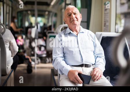 Homme âgé assis en tram Banque D'Images
