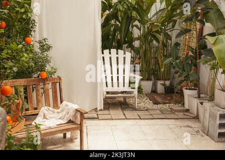 Jardin d'époque avec banc en bois et chaise blanche Banque D'Images