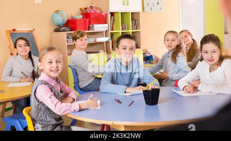 Des écoliers diligents assis en classe à l'écoute attentive Banque D'Images