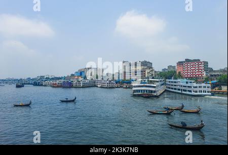 Beau paysage du port de la rivière Sadarghat sur le fleuve Buriganga à Dhaka. Ferry sur la rivière avec un fond ciel nuageux. Banque D'Images