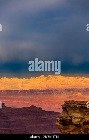 Nuages de pluie colorés au coucher du soleil sur la région de Behind the Rocks, vue depuis Shafer Canyon Overlook, parc national de Canyonlands, Utah. Dead Horse point à gauche Banque D'Images