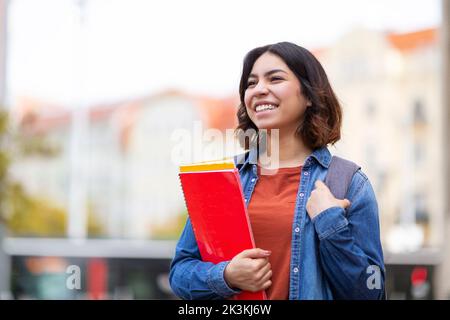 Portrait d'une jeune étudiante arabe heureuse debout à l'extérieur Banque D'Images