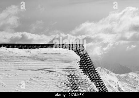 Toit de l'hôtel dans la neige et les montagnes d'hiver. Montagnes du Caucase, Géorgie, station de ski Gudauri. Image en noir et blanc. Banque D'Images