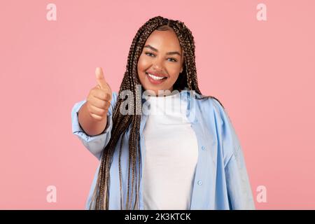 Bonne Black Lady gestante Thumbs Up signe sur fond rose Banque D'Images