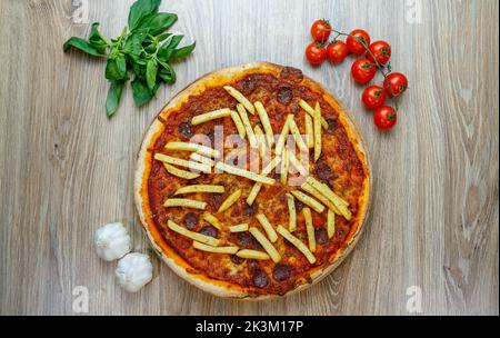 Une vue de dessus de Pizza Patatosa avec des saucisses chaudes et des frites dans la sauce tomate avec des ingrédients à côté Banque D'Images