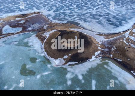 Vue du haut vue pittoresque de drone des pseudocratères de Skutustadagigar couverts de neige situé sur la rive du lac Myvatn en hiver nuageux en Islande Banque D'Images