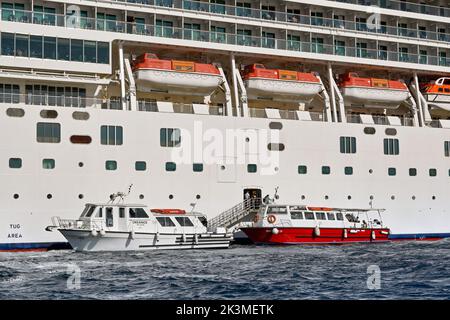 Mykonos, Grèce - Mai 2022 : petits bateaux à moteur collectant les passagers d'un bateau de croisière amarré au large de l'île grecque de Mykonos Banque D'Images