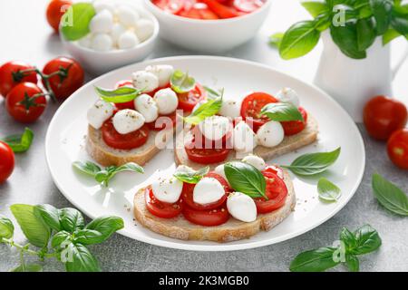 Toasts de Caprese avec mini-fromage mozzarella, tomates cerises et basilic Banque D'Images