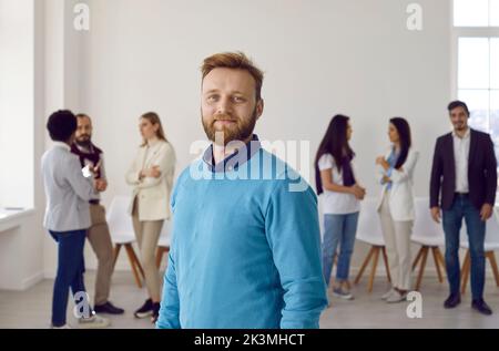 Portrait d'un homme d'affaires ou d'un employé de bureau heureux debout au bureau et regardant l'appareil photo Banque D'Images