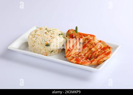 Schezwan poulet frit riz dans un bol blanc isolé sur fond blanc. Le riz Szechuan est un plat indo-chinois de cuisine avec poivrons, haricots verts, voiture Banque D'Images