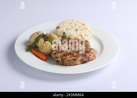 Schezwan poulet frit riz dans un bol blanc isolé sur fond blanc. Le riz Szechuan est un plat indo-chinois de cuisine avec poivrons, haricots verts, voiture Banque D'Images