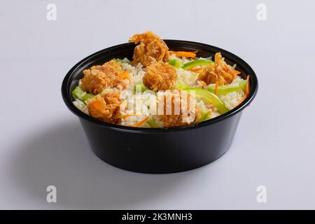 Schezwan poulet frit riz dans un bol blanc isolé sur fond blanc. Le riz Szechuan est un plat indo-chinois de cuisine avec poivrons, haricots verts, voiture Banque D'Images