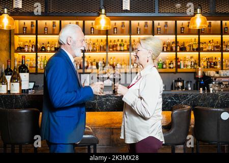 Deux personnes qui font un toast au bar Banque D'Images