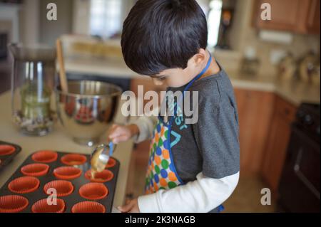 Un petit garçon qui fait cuire des gâteaux Banque D'Images