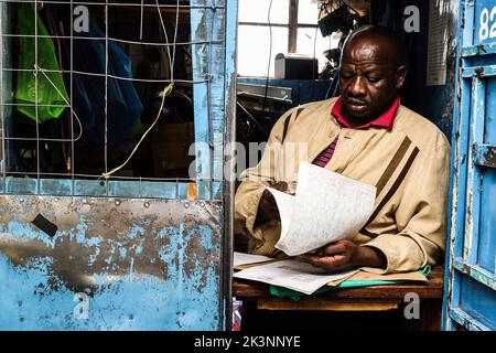 Nakuru, Kenya, 27/09/2022, Josephat Mureithi, frère de William Munuhe, journaliste kenyan tué, périt des lettres et des documents de la cour lors de son atelier d'électronique à Nakuru Town. Dirigé par Josephat, la famille de feu William Munuhe qui a été tué sur 14 janvier 2003, comme il a aidé la police et le Bureau fédéral des enquêtes (FBI) des États-Unis à traquer le fugitif de génocide rwandais, Felicien Kabuga, est toujours en quête de justice 19 ans plus tard. Felicien Kabuga (89), a été chassé de sa cachette en France après 26 ans en course et sera présenté au mécanisme résiduel international d'UNís pour l'IRC Banque D'Images