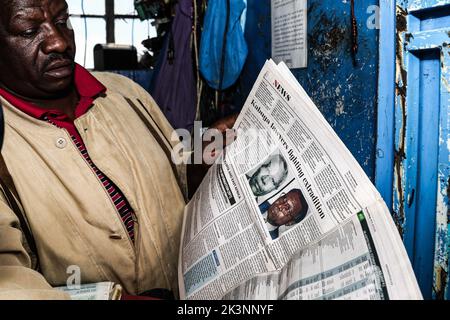 Nakuru, Kenya, 27/09/2022, Josephat Mureithi, frère du journaliste kenyan tué William Munuhe, lit un vieux journal kenyan qui a couvert l'histoire du génocide rwandais fugitif Felicien Kabuga lors de son atelier d'électronique à Nakuru Town. Dirigé par Josephat, la famille de feu William Munuhe qui a été tué sur 14 janvier 2003, comme il a aidé la police et le Bureau fédéral des enquêtes (FBI) des États-Unis à traquer le fugitif de génocide rwandais, Felicien Kabuga, est toujours en quête de justice 19 ans plus tard. Felicien Kabuga (89 ans), a été chassé de son cachette en France après 26 ans en course et sera Banque D'Images