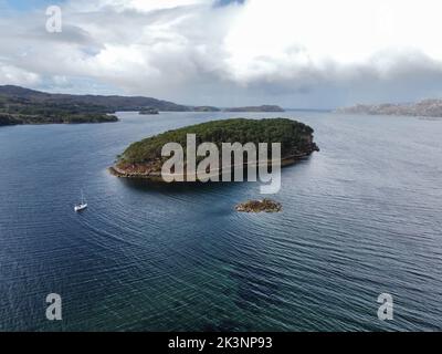 Une vue aérienne d'une petite île boisée sous un ciel nuageux Banque D'Images