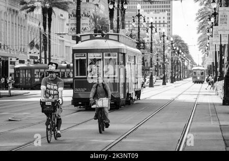 Cyclistes qui longent Canal Street à la Nouvelle-Orléans, en Louisiane, devant une voiture de rue. Banque D'Images