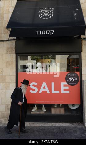 Un homme des religions israéliennes marchant à côté de la boutique de vêtements Castro sur la rue King George V à Jérusalem, Israël. Banque D'Images