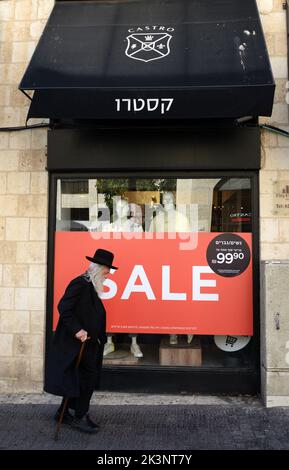 Un homme des religions israéliennes marchant à côté de la boutique de vêtements Castro sur la rue King George V à Jérusalem, Israël. Banque D'Images