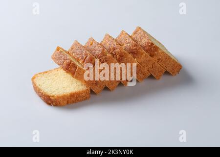 Tranches de délicieux gâteau au beurre de canneberges séchées ou gâteau de livre sur plaque blanche et quelques ingrédients sur table en bois avec espace de copie pour le fond ou wa Banque D'Images