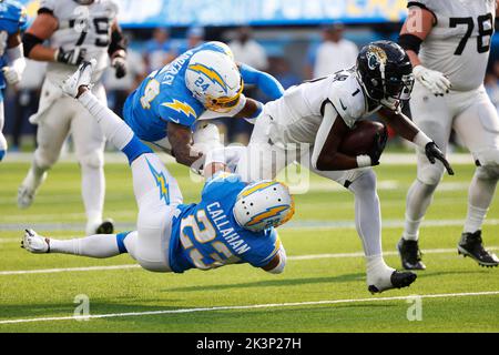 25 septembre, 2022 Jacksonville Jaguars en arrière Travis Etienne Jr. (1) porte le ballon tandis que Nasir Adderley (24) et Bryce Callahan (23), au coin de Los Angeles Chargers, font l'affaire pendant le match de football de la NFL entre les Chargers de Los Angeles et les Jacksonville Jaguars au stade SOFI À Inglewood, Californie. Crédit photo obligatoire : Charles Baus/CSM Banque D'Images