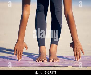 Étirez-la. Une femme méconnaissable pratiquant le yoga sur la plage. Banque D'Images