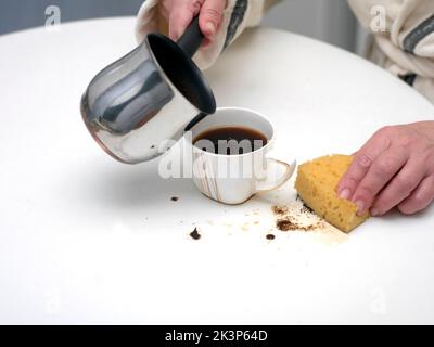 Femme et juste renversé le café sur la table, à l'intérieur de gros plan Banque D'Images