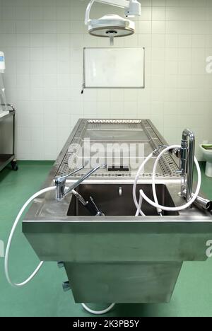 Table d'opération en acier inoxydable utilisée pour effectuer des travaux de dissection dans une autopsie Banque D'Images