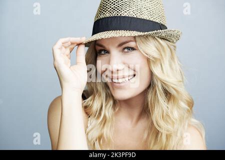 Ce chapeau est très tendance. Portrait studio d'une magnifique jeune femme blonde portant un chapeau. Banque D'Images