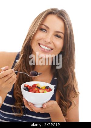 Une alimentation saine. Une jolie jeune femme qui apprécie un bol de salade de fruits. Banque D'Images