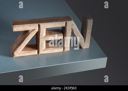 Le mot Zen sculpté dans des lettres en bois sur fond gris, concept de style de vie équilibré . Banque D'Images