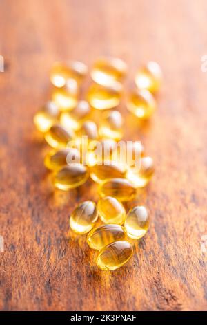 Capsules d'huile de poisson. Pilules jaunes omega 3 sur table en bois. Banque D'Images