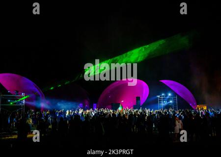 Des lumières laser colorées brillent et se déplacent sur la foule dansante pendant la fête du DJ Banque D'Images