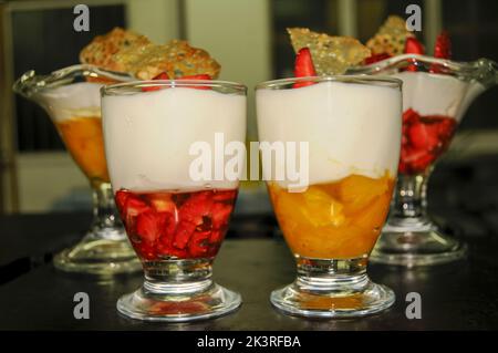 Préparation de yaourt et de mousse de fruits dans des tasses en verre Banque D'Images