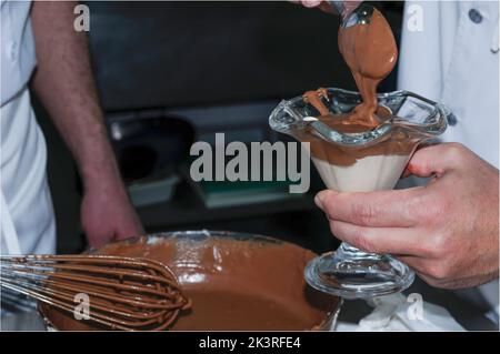 Chef préparant de la mousse au chocolat dans une tasse de verre Banque D'Images
