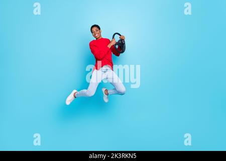 Photo pleine longueur positive millénaires court hairdo Guy saut Drive porter pull-over jeans chaussures isolées sur fond bleu Banque D'Images