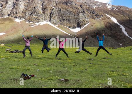 5 personnes sautant avec joie avec une montagne en arrière-plan Banque D'Images